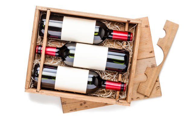 istock Opened wooden box with three red wine bottles inside it isolated on white background 878415432
