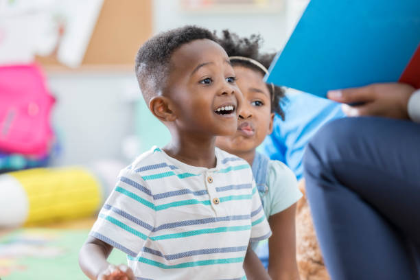 возбужденный дошкольников наслаждаясь история времени - preschooler toddler classroom learning стоковые фото и изображения