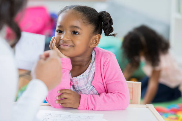 istock Confident African American preschool student reviewing flashcards 878418242