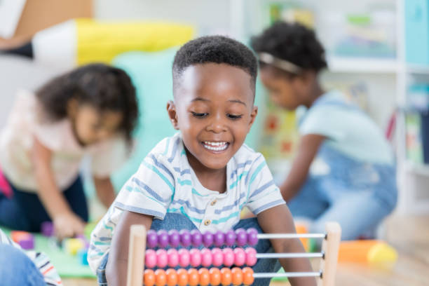 istock Adorable male preschooler plays with abacus 878418248