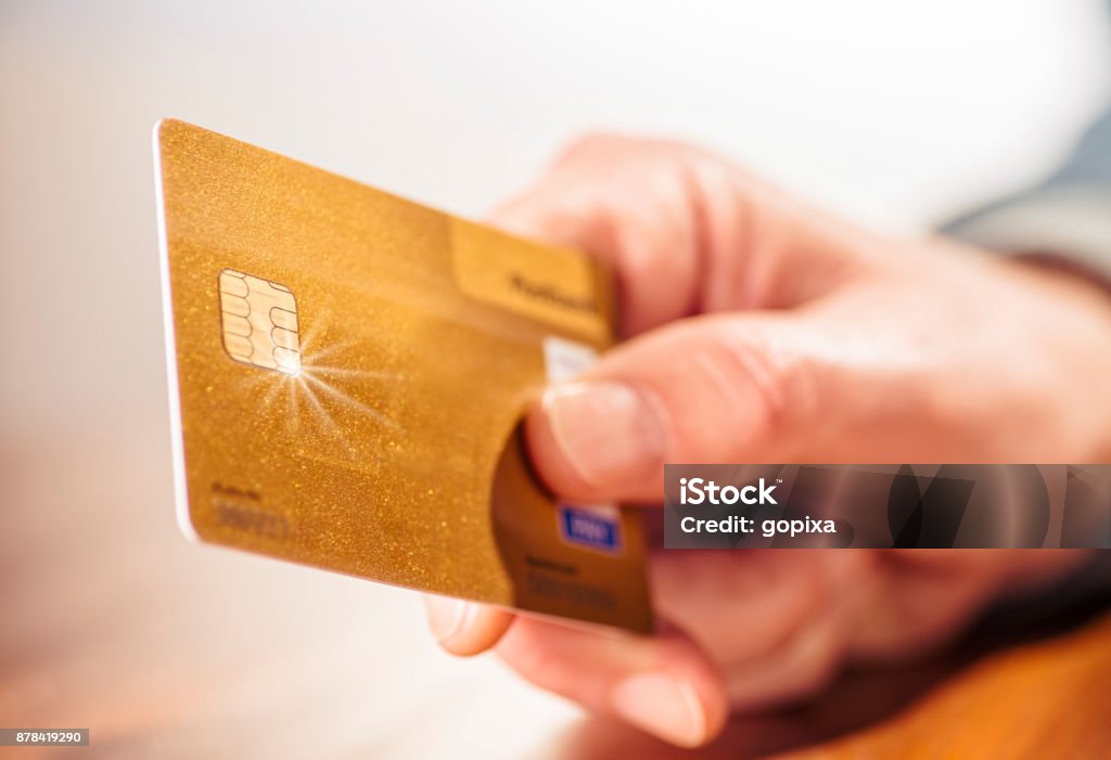 Hand with golden credit card Close-up of a hand with a golden credit card Credit Card Stock Photo