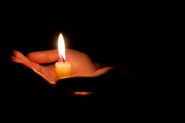 istock hands holding a burning candle in dark like a heart 878421990