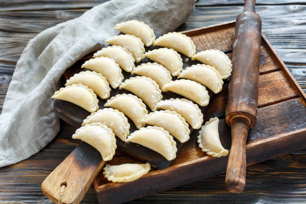 Ready for cooking dumplings with cottage cheese. Homemade dumplings with cottage cheese on wooden Board, selective focus. pierogi stock pictures, royalty-free photos & images