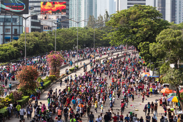 Large crowd during Jakarta car free day held every Sunday in Indonesia capital city JAKARTA, INDONESIA - OCTOBER 15, 2017: A huge crowd attends the car free day along Sudirman street in the heart of Jakarta business district. The event, hold every Sunday, is suppose to fight pollution and traffic congestion. jakarta skyline stock pictures, royalty-free photos & images