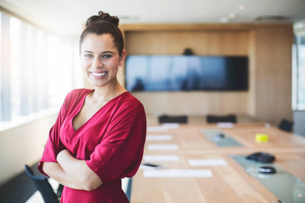 istock Young female executive standing with arms crossed 878427278
