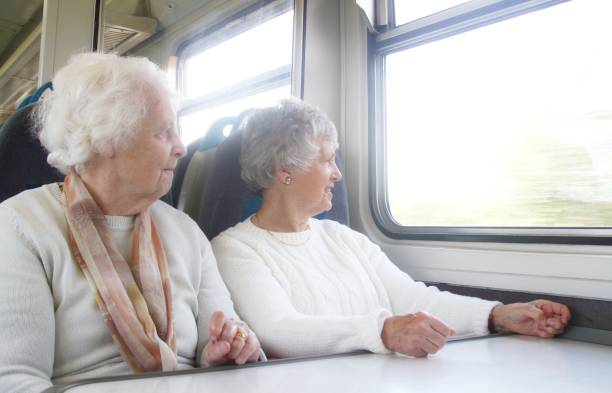 istock two senior women on train journey 878427346