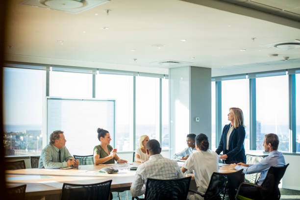 istock Multi-ethnic colleagues discussing in board room 878439876