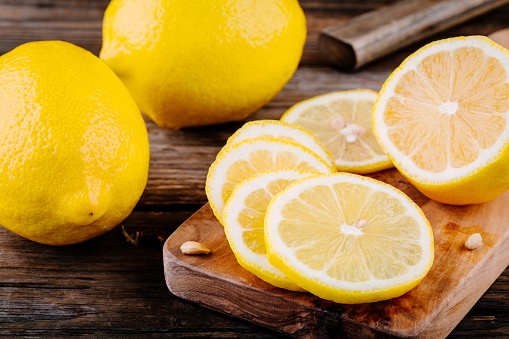 Fresh ripe lemon slices on wooden rustic background