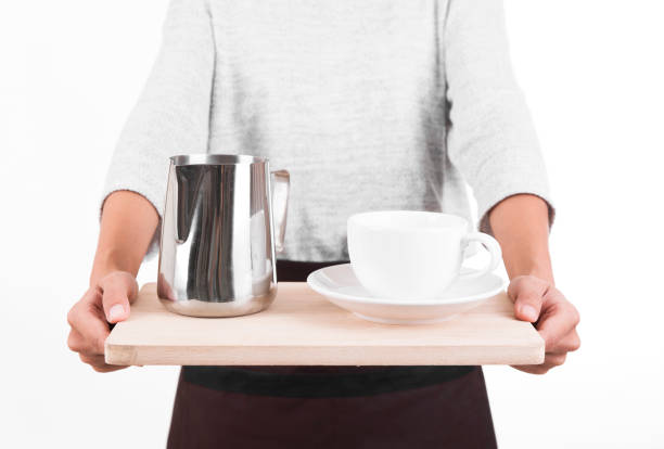 istock waitress in a apron with a tray in his hand cup coffee and milk pitcher. Service Concept 878443728