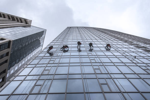 istock Window washers cleaning the glass facade of a skyscraper 878447358