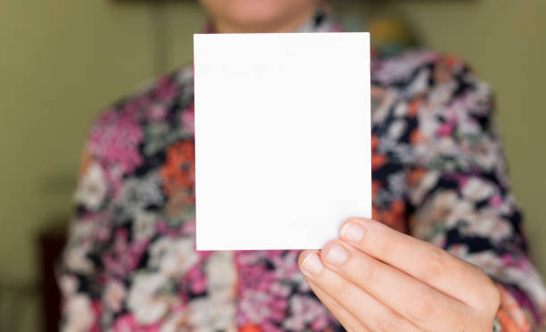 istock Woman holding white blank paper 878473372