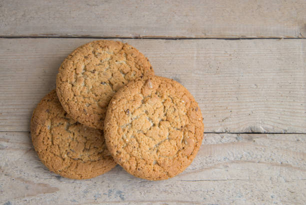 istock Stack of freshly baked oat biscuits on wooden background 878494270