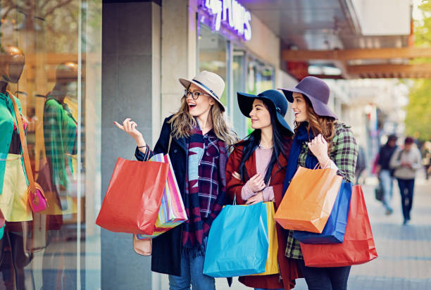 istock Girlfriends are shopping and looking in the store window 878496832