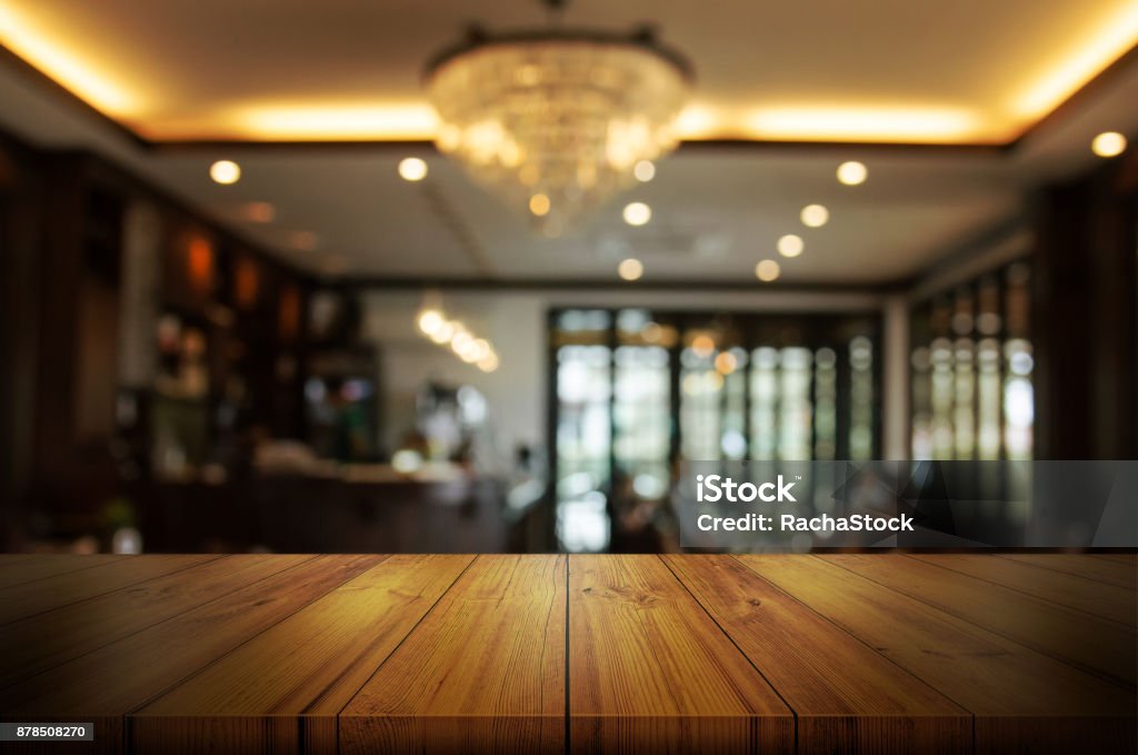 Empty wooden table top with blur coffee shop or restaurant interior background. Abstract background can be used product display. Coffee Shop Stock Photo