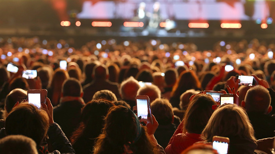 many young people with smart phones at live concert