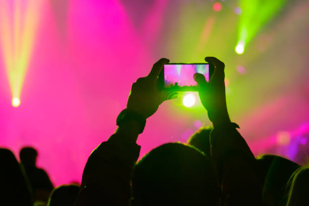 istock Concert visitor shoots video 878531544
