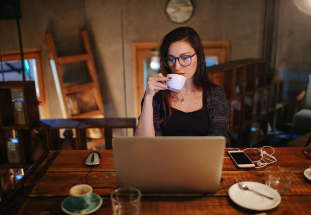 istock Young woman working late in her coworking space 878534378