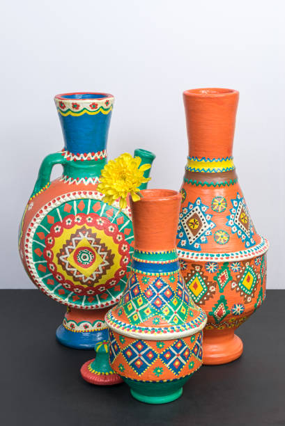 istock Orange ornate pottery vases on black table and white wall 878547910