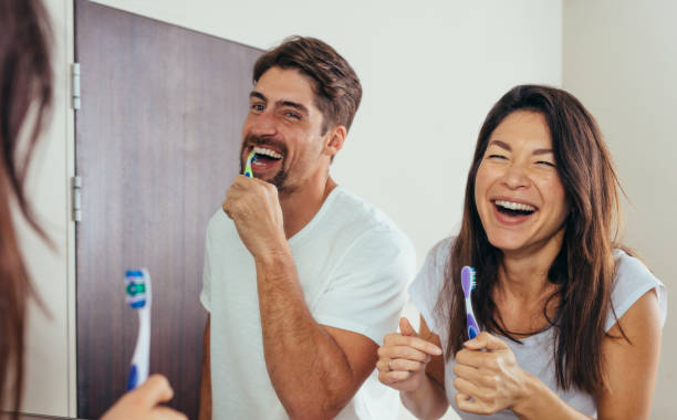 istock Smiling couple brushing teeth in bathroom 878562458