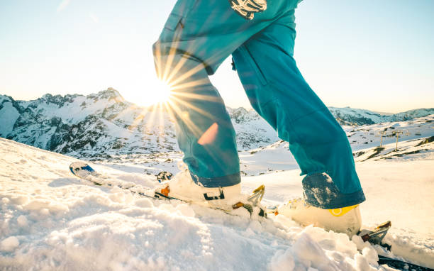 jambes de skieur professionnel au coucher du soleil sur relax moment en français point de vue côté alpes ski resort - concept de sport d’hiver avec guy aventure au sommet de la montagne prêt à rouler vers le bas - avec filtre vintage azur - ski winter women skiing photos et images de collection