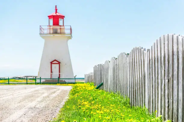 Bonaventure village pointe lighthouse in Quebec, Canada Gaspesie region with red and white painted colors, fence