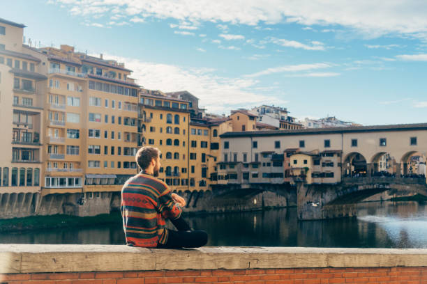 istock Man resting with view on Ponte Vecchio  of Florence, Italy 878578950