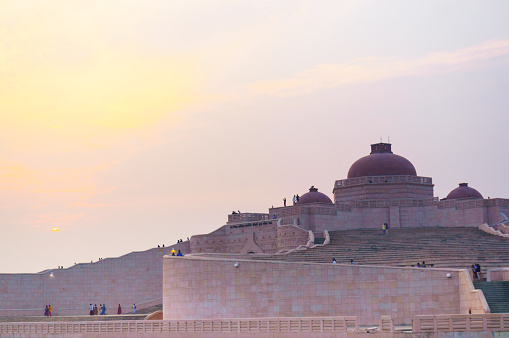 Close up shot of the Ambedkar stupa at sunset. The path leading to the top and the domed roof are clearly visible