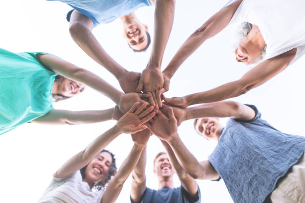 istock Ethnic group of adults with hands in stack celebrate teamwork 878581936