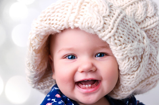 Caucasian baby girl portrait in knitted hat.Winter child's fashion concept.