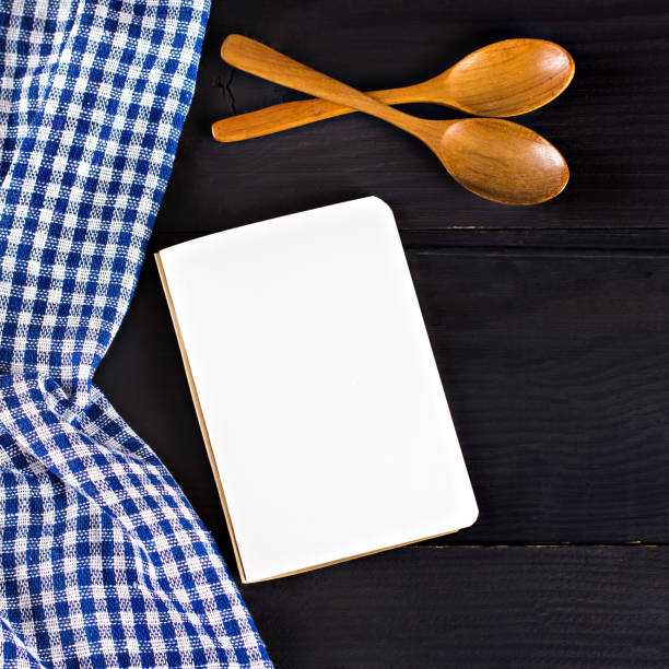 istock A blue kitchen towel and a notebook on a dark wooden background. Menu, place for text, recipe. 878586468