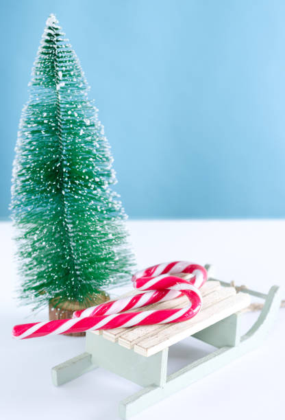 istock Wooden sled with sweets and Christmas tree on white background. 878599274