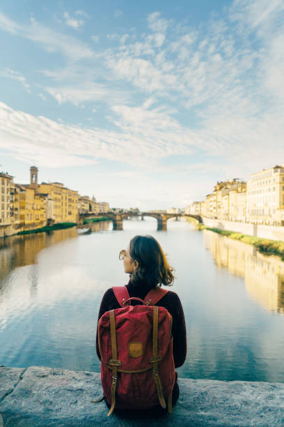 istock Woman sitting on Ponte Vecchio   with view  om Florence, Italy 878611088