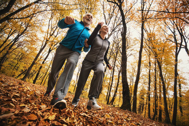 istock Senior couple jogging in a forest. 878626770