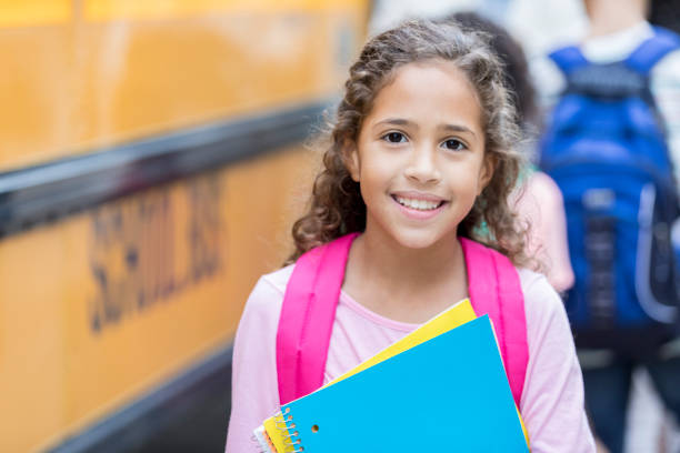 istock Cheerful student waits to load school bus 878636060