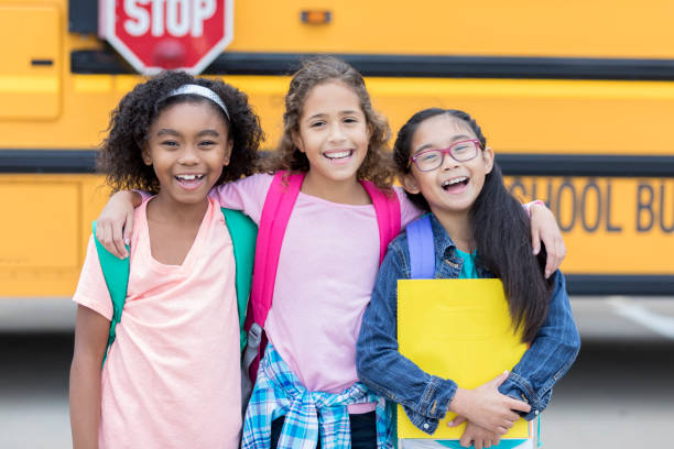 istock Diverse schoolgirls wait to get on school bus 878636082