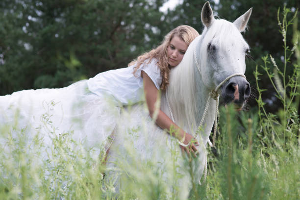 istock Girl hugging white horse 878636722