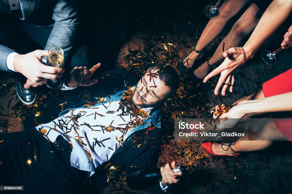 Soirée de folie. Homme ivre allongé sur le sol - Photo de Fête libre de droits