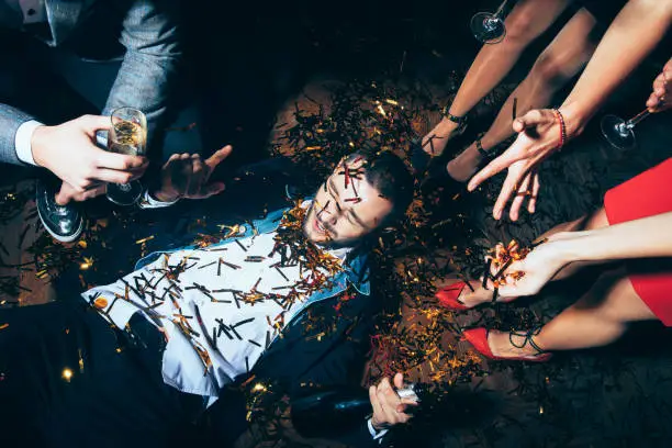 Photo of Crazy party. Drunk man lying on floor
