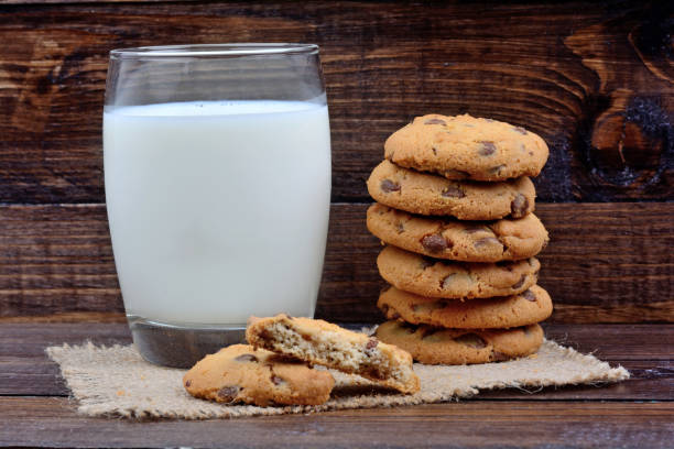 istock Glass with milk and cookies on wooden background 878650310