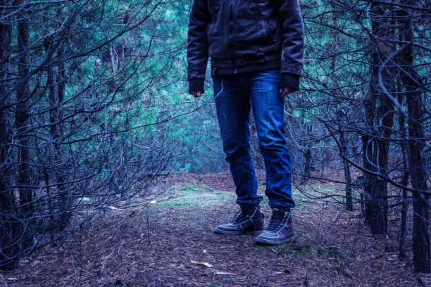 Photo of giant man stands on a path leading to a mysterious forest