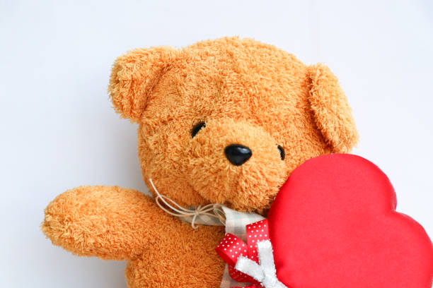 istock Cute Teddy bear with red heart symbol on white background 878674392