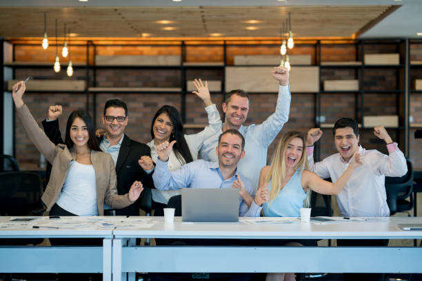 successful business group celebrating an achievement at the office - team work celebrating imagens e fotografias de stock