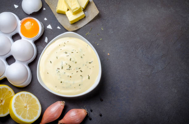 basic french sauce bearnaise in a white bowl with ingredients, b - hollandaise sauce imagens e fotografias de stock