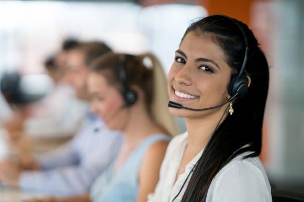 felice donna latinoamericana che lavora in un call center - call center foto e immagini stock