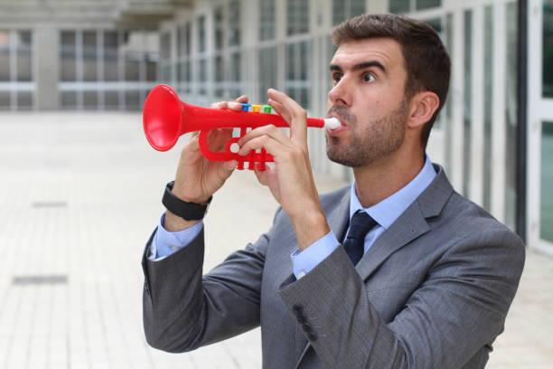 istock Man playing plastic trumpet in the office 878705710