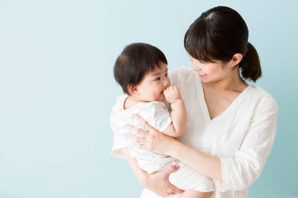 アジアの母と赤ちゃんの青い背景に分離 - two generation family 写真 ストックフォトと画像
