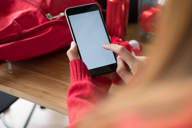 istock woman wearing red sweater using smartphone for social networking. girl typing text message on application in mobile phone. technology, communication 878717580