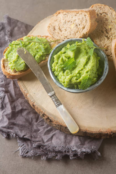istock Baguette with mashed green peas and mint. Dark background. Selective focus. Top view 878717724
