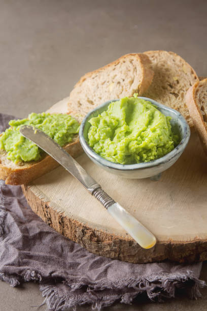 istock Baguette with mashed green peas and mint. Dark background. Selective focus. 878717830