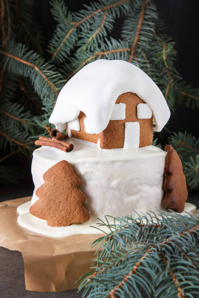 New Year cake with Christmas trees and gingerbread houses and cinnamon. Dark background.